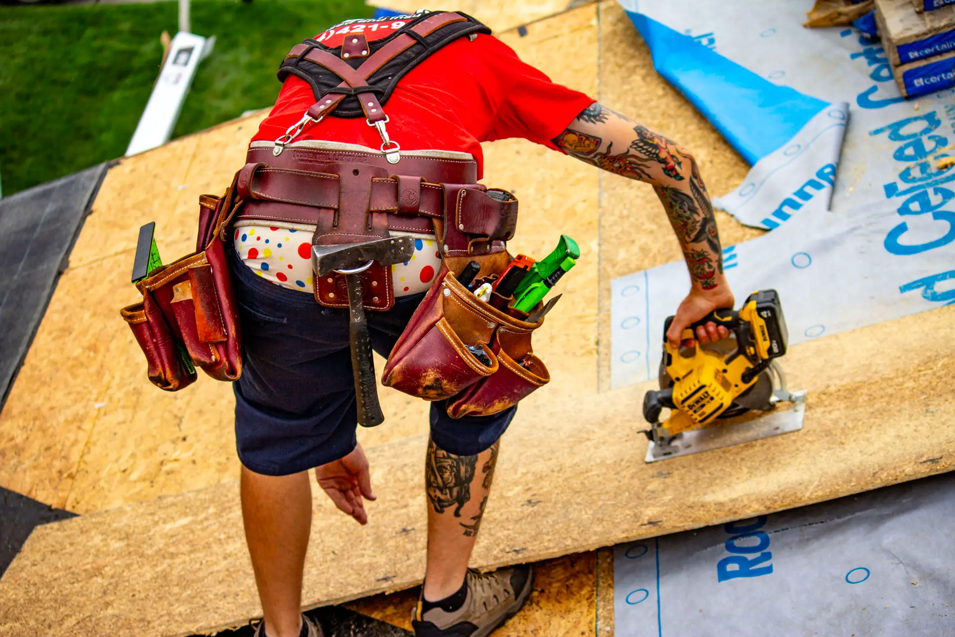 Billy's Roofing crew member cutting wood for roof repair in Metro Detroit.