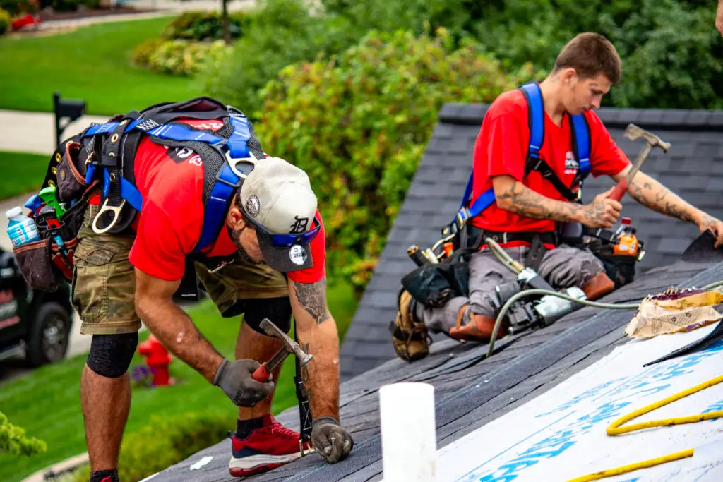 Billy's Roofing crew members installing shingles during roof replacement in Metro Detroit.