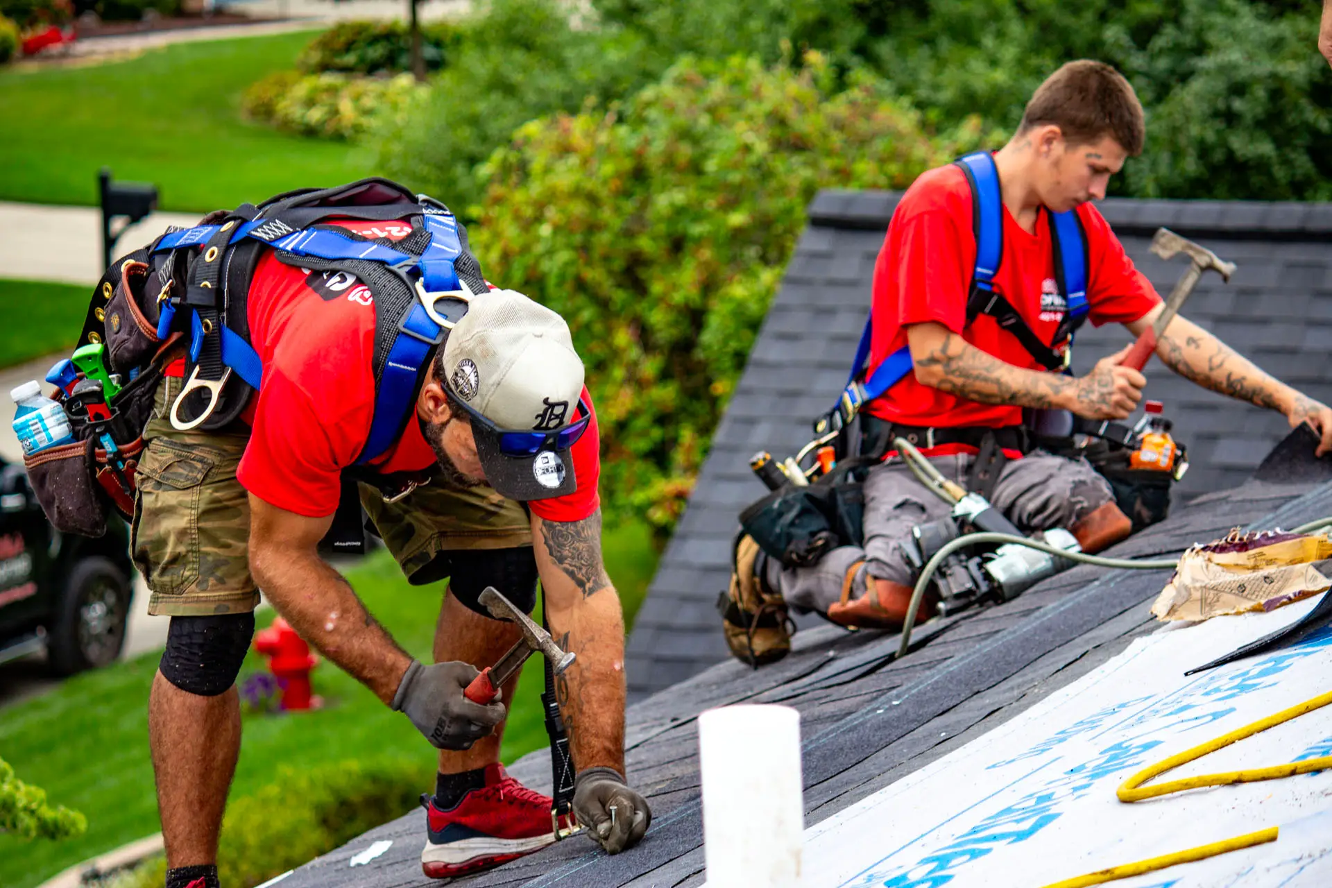 Billy's Roofing crew members installing shingles during roof replacement in Metro Detroit.