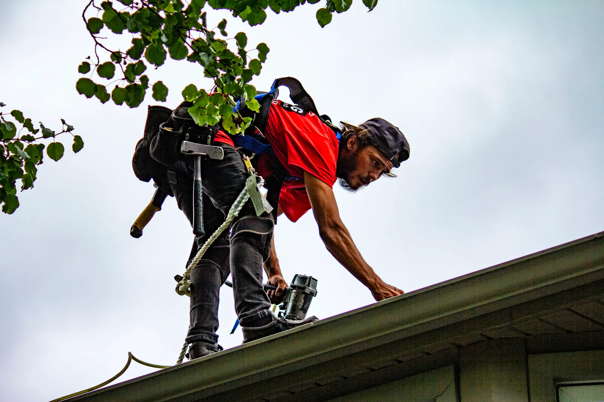 Billy’s Roofing crew member installing asphalt shingles on residential roof in Metro Detroit.