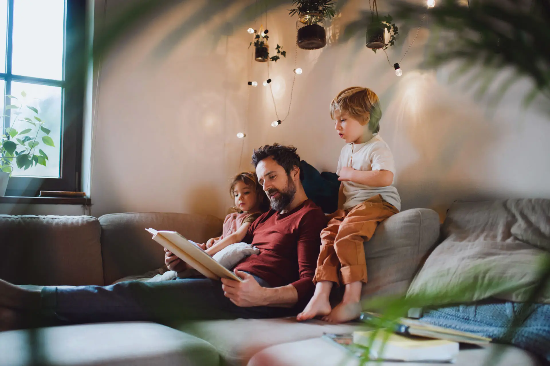 Father reading on couch with his children.