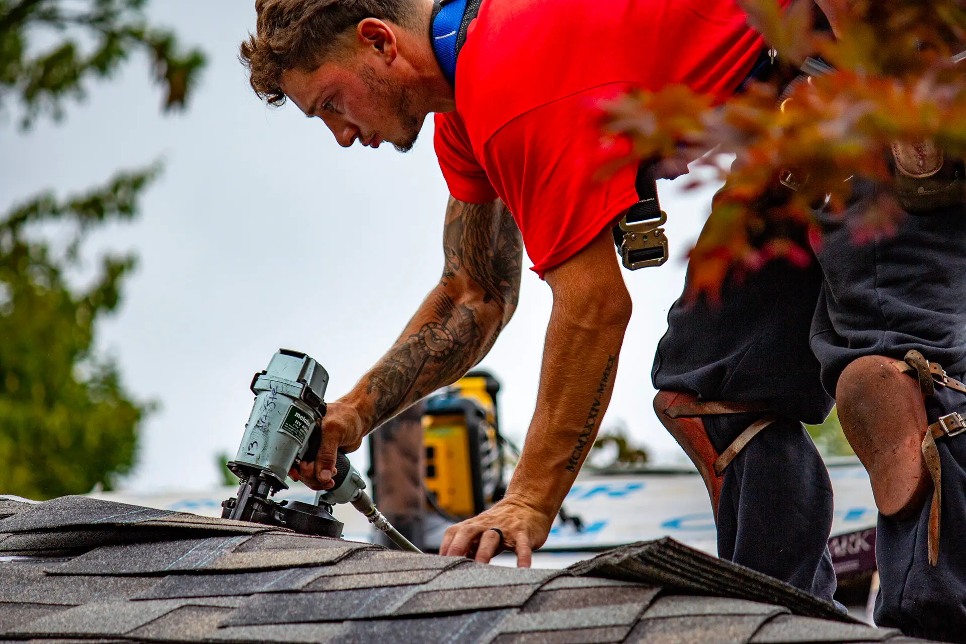 Billy's Roofing crew member installing shingles during roof replacement in Metro Detroit.
