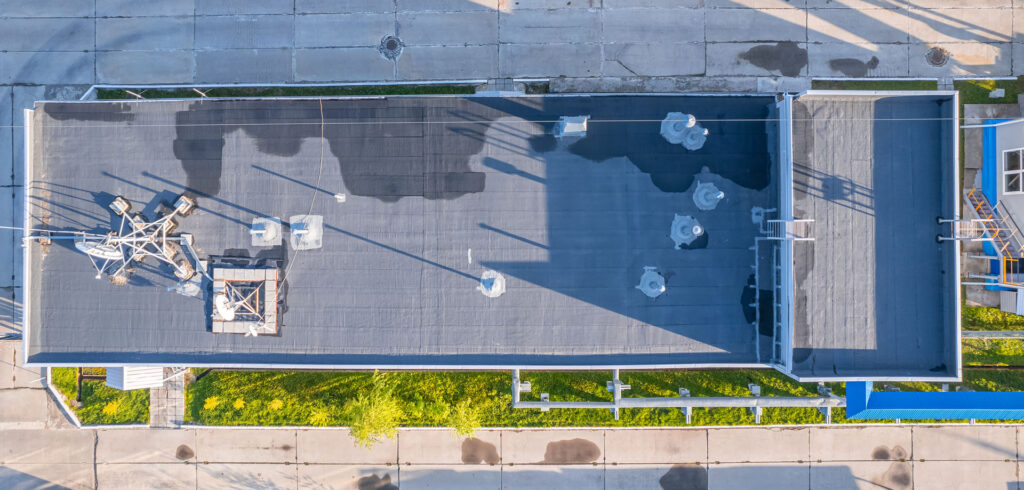 Aerial view of a commercial flat roof being evaluated during an inspection